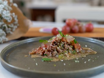 Tártaro de carne maturada com romã "Adoora" e pickles de uva "Dona Uva"